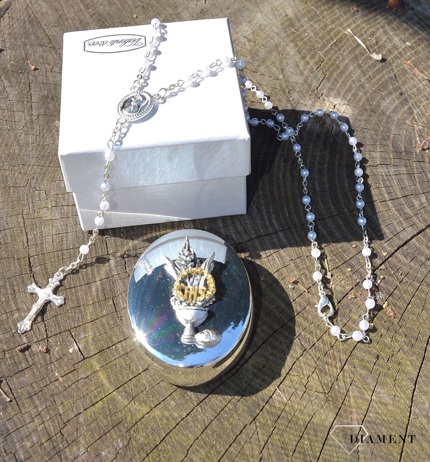 Różaniec komunijny z koralików w kolorze perłowym w pięknym, ozdobnym posrebrzanym opakowaniu. Komunia Św. to 4 symbole różaniec, książeczka, medalik oraz świeca (1).JPG